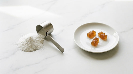 Creatine powder with metal scoop next to amber bear-shaped gummies on ceramic plate